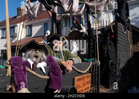 Andrew Carvel avec le bateau pirate géant « Elizabeth Dane » qu'il a construit en utilisant du bois de ferraille dans le jardin de sa maison à Tamworth, Staffordshire.Le navire mesure neuf mètres de long et est orné d'un drapeau pirate, de squelettes et de voiles sanglées, et il a fallu quelques semaines à M. Carvel pour le construire.Date de la photo: Jeudi 21 octobre 2021. Banque D'Images