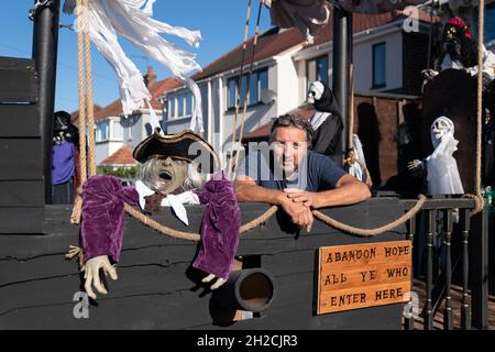 Andrew Carvel avec le bateau pirate géant « Elizabeth Dane » qu'il a construit en utilisant du bois de ferraille dans le jardin de sa maison à Tamworth, Staffordshire.Le navire mesure neuf mètres de long et est orné d'un drapeau pirate, de squelettes et de voiles sanglées, et il a fallu quelques semaines à M. Carvel pour le construire.Date de la photo: Jeudi 21 octobre 2021. Banque D'Images