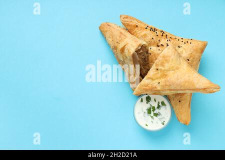 Golden samsa avec des ingrédients sur fond bleu Banque D'Images