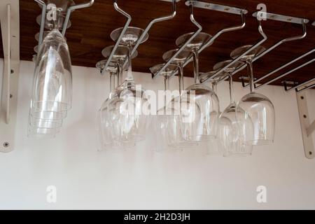 Verres à vin suspendus dans un support. Organisés à l'intérieur du placard. Rangement intérieur pour la maison Banque D'Images