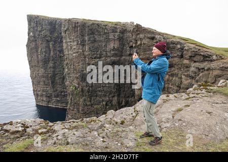 Tourisme prendre une photo près de la falaise de Trælanípan, Traelanipa, Tralanipa Trail, Midvagur/Sandavágur, Vagar Island,Îles Féroé, Scandinavie, Europe. Banque D'Images