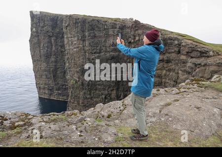 Tourisme prendre une photo près de la falaise de Trælanípan, Traelanipa, Tralanipa Trail, Midvagur/Sandavágur, Vagar Island,Îles Féroé, Scandinavie, Europe. Banque D'Images