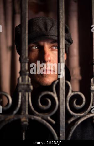 Un homme sous un manteau et un chapeau se promène dans la ville. Banque D'Images