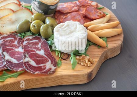 Carte de tapas très colorée de charcuterie avec fromage et viandes fumées.Décoration avec arugula et noix.En-cas au vin. Banque D'Images