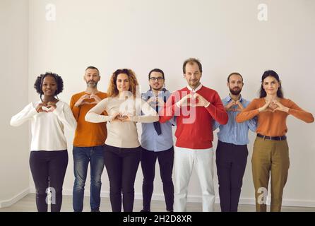 Portrait de groupe de personnes diversifiées et heureuses debout ensemble et faisant le geste du cœur Banque D'Images