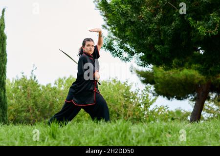 Femme en uniforme pratiquant les arts martiaux avec une épée Banque D'Images