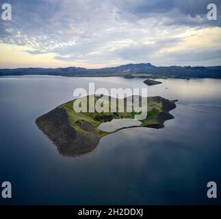 Vue imprenable sur l'île verte de drone située dans l'eau de l'étang calme sous le ciel de coucher de soleil en Islande Banque D'Images