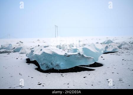 Vue panoramique sur les morceaux de glacier sur un terrain enneigé avec ombre sous le ciel bleu le jour ensoleillé en Islande Banque D'Images