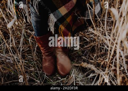 Tenue automnale avec chaussures rétro en cuir pour femme et tissu écossais sur gazon sec Banque D'Images