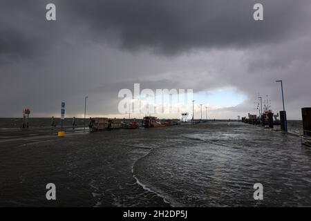 21 octobre 2021, Schleswig-Holstein, Dagebüll: L'eau se trouve sur le quai du terminal de ferry à Dagebüll, tandis que le niveau de la mer du Nord s'élève.En arrière-plan, des nuages de pluie sombres et le début du ciel bleu peuvent être vus.Le bas 'Ignatz' se déplace au-dessus du Schleswig-Holstein jeudi.Photo: Bodo Marks/dpa Banque D'Images