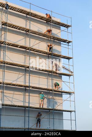 UZHGOROD, UKRAINE - 16 septembre 2021 : ouvriers de la construction mettant du plâtre décoratif à l'extérieur de la maison.Isolation thermique de façade et travaux de peinture Banque D'Images