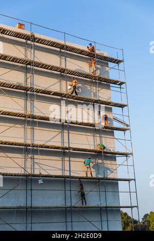 UZHGOROD, UKRAINE - 16 septembre 2021 : ouvriers de la construction mettant du plâtre décoratif à l'extérieur de la maison.Isolation thermique de façade et travaux de peinture Banque D'Images