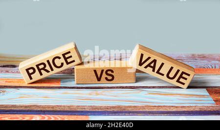 Blocs en bois avec l'inscription Price vs Value sur fond bleu Banque D'Images