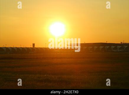 Superbe soleil éclatant sur un terrain d'herbe dorée à l'extérieur de l'aéroport Banque D'Images