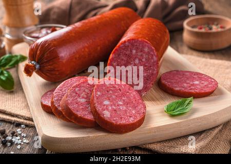 Gros plan sur une planche à découper avec saucisse fumée aux épices.Vue latérale, gros plan. Banque D'Images