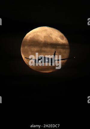 Castle Donington, Derbyshire, Royaume-Uni.21 octobre 2021.Météo au Royaume-Uni.Un avion passe la lune gibbbbonique en déclin alors qu'il se rend à l'aéroport des Midlands de l'est.Credit Darren Staples/Alay Live News. Banque D'Images