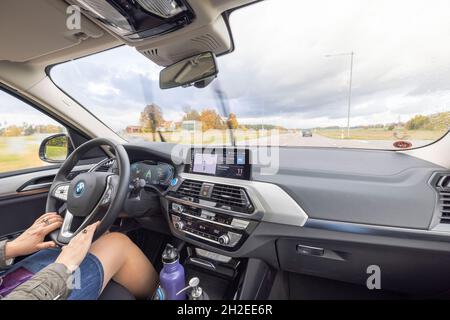 Vue rapprochée de l'intérieur du BMWiX3 sur la route.Conducteur femelle dans le véhicule.Suède.Uppsala. Banque D'Images