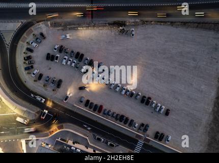 Drone vue aérienne des parkings avec voitures la nuit.Un parking de centre commercial bondé. Banque D'Images