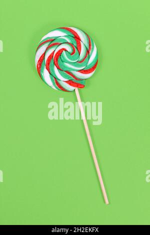 Lollipop avec des couleurs de Noël sur fond vert Banque D'Images