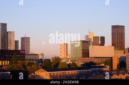 Tôt le matin, un ciel dégagé pour la pleine lune déclinante parmi les gratte-ciels de Manchester, au Royaume-Uni. Banque D'Images