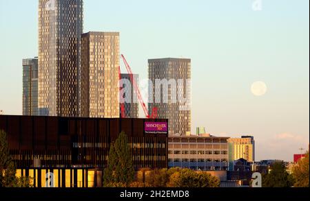 Tôt le matin, un ciel dégagé pour la pleine lune déclinante parmi les gratte-ciels de Manchester, au Royaume-Uni. Banque D'Images