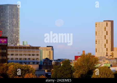 Tôt le matin, un ciel dégagé pour la pleine lune déclinante parmi les gratte-ciels de Manchester, au Royaume-Uni. Banque D'Images