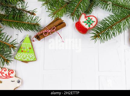 Pain d'épice et branches de sapin sur table blanche.Carte de vœux de Noël, maquette avec espace de copie Banque D'Images
