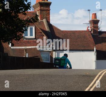 Uber mange le conducteur de livraison vu avec une grande boîte de livraison sur son dos lorsqu'il descend une colline pendant la journée en octobre 2021. Banque D'Images