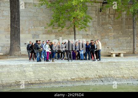 Un grand groupe de personnes lors d'une visite guidée est pris en charge par le guide au bord de la Seine, Paris, France Banque D'Images