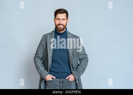 Beau homme d'affaires caucasien réussi en costume formel portrait sur bleu Banque D'Images