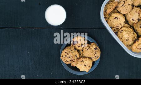 Plat de biscuits aux pépites de chocolat et de lait de fond en bois noir Banque D'Images