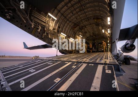 Des aviateurs américains du 332e Escadron de préparation logistique déchargent le fret d'un C-17 Globemaster III le 18 octobre 2021, à un endroit non divulgué quelque part en Asie du Sud-Ouest le C-17, de la base aérienne de Travis, en Californie,Livraison de matériel pour le 26e Escadron de sauvetage expéditionnaire à l’appui de la mission de la 332e Escadre expéditionnaire aérienne.(É.-U.Photo de la Force aérienne par le premier Airman Karla Parra) Banque D'Images