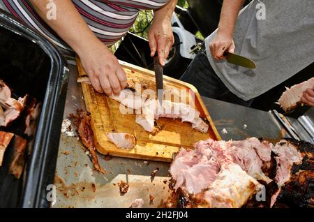 Couper et sculpter le porc entier rôti à la broche, dans une ferme du Midwest, Blanchardville, Wisconsin, États-Unis Banque D'Images