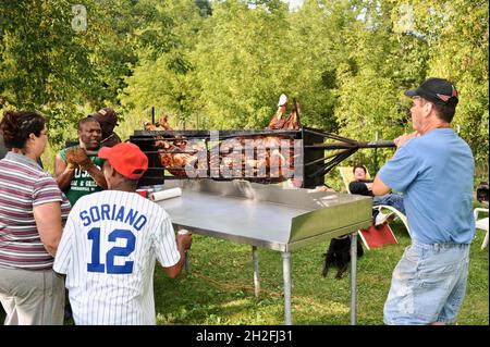Déplacer le porc entier torréfié à la table de préparation à l'extérieur, dans une ferme du Midwest, Blanchardville, Wisconsin, États-Unis Banque D'Images