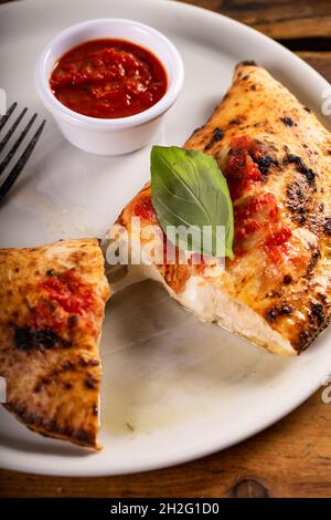 Calzone italienne avec sauce marinara entière sur une assiette Banque D'Images