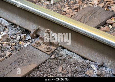 Gros plan de l'usure latérale accrue des rails en acier avec des copeaux métalliques dans une courbe très raide. Banque D'Images