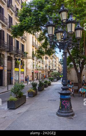 Barcelone, Espagne - 22 septembre 2021 : lampe de rue antique dans un paysage urbain traditionnel typique.Les maisons avec des balcons étroits avec des rampes en fer.Arbre Banque D'Images