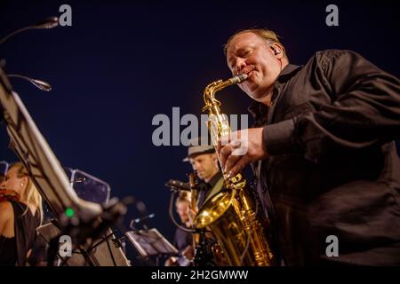Musicien de sexe masculin jouant du saxophone sous le ciel bleu de la nuit Banque D'Images