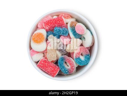 Gommes aux arômes de fruits bonbons avec un revêtement de sucre aigre dans un bol en céramique sur fond blanc.Vue de dessus Banque D'Images