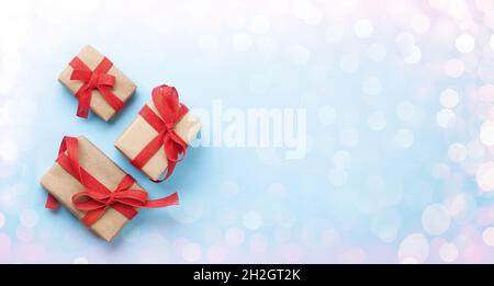 Boîtes cadeau de Noël sur fond bleu avec bokeh et espace pour vos voeux.Plan d'étapage avec vue de dessus Banque D'Images