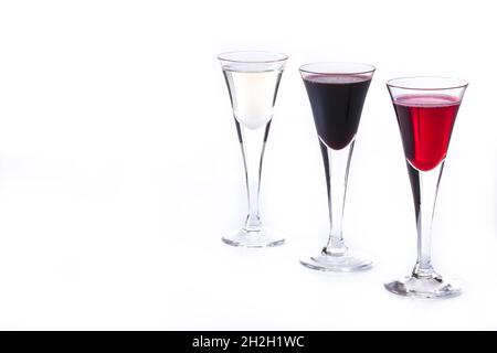 trois verres avec différentes liqueurs de couleurs isolées sur fond blanc Banque D'Images