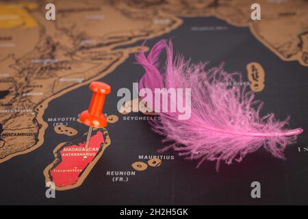 Lieu Madagascar.PIN rouge et plume rose sur la carte. Gros plan, concept de voyage Banque D'Images