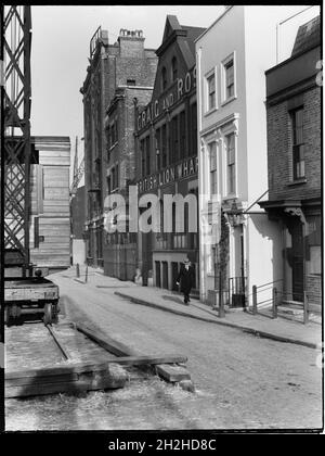 Bankside, Southwark, Greater London Authority, 1925-1935.Vue vers l'est le long de Bankside, sur le côté sud de la Tamise, montrant un homme passant devant British Lion Wharf et Cardinals Wharf au numéro 49.Le quai des cardinaux, situé au 49 Bankside, est toujours debout, mais le site sur lequel se trouvait le British Lion Wharf et l'entrepôt au-delà est maintenant occupé par le Globe de Shakespeare. Banque D'Images