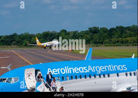 IGUAZU, ARGENTINE - 25 avril 2019 : un avion de la compagnie aérienne à bas prix Flybondi prend son envol tandis que les passagers descendent d'Aerolineas Argentinas Banque D'Images