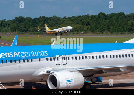 IGUAZU, ARGENTINE - 25 avril 2019 : un avion de la compagnie aérienne à bas prix Flybondi prend son envol tandis que les passagers descendent d'Aerolineas Argentinas Banque D'Images