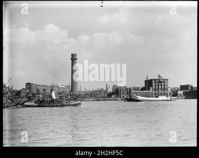 Tour de tir et Lead Works, Belvedere Road, Lambeth, Greater London Authority, 1936.Vue sur la Tamise vers la tour de tir de Lambeth Lead Works avec la brasserie Lion sur la droite.La tour de tir du Lambeth Lead Works a été conçue par David Ridall Roper et a été construite en 1826 pour Thomas Maltby &amp; Co. Au moment de cette photographie, elle était exploitée par Walkers, Parker & amp;Co mais il a été démoli plus tard en 1962 pour faire place à la salle de la Reine Elizabeth.La brasserie Lion a été construite en 1836-37, mais elle a été démolie en 1949 pour faire place à la salle des fêtes royale. Banque D'Images