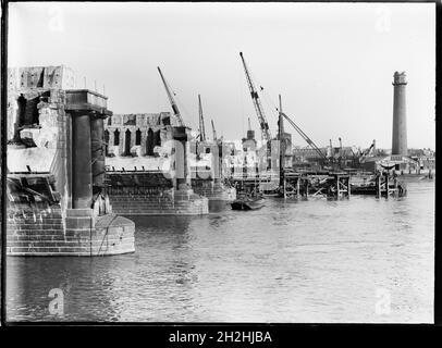 Démolition du pont Waterloo, Lambeth, Greater London Authority, 1936.Vue sur la Tamise montrant la démolition de l'ancien pont de Waterloo, avec la tour de tir à la Lambeth Lead Works à droite de l'arrière-plan.Le pont de Waterloo, qui est présenté pendant sa démolition, a été conçu par John Rennie et a ouvert ses portes en 1817.Il a été démoli dans les années 1930 avec un autre pont le remplaçant dans les années 1940. Banque D'Images