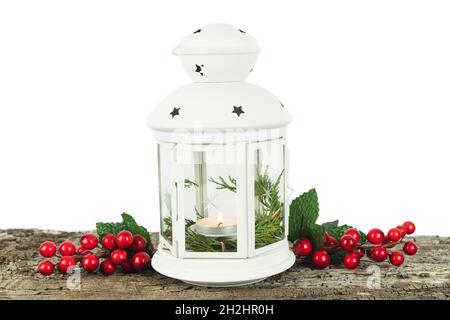 Lanterne blanche avec bougie à l'intérieur et décoration de Noël sur panneau de bois et mur blanc de fond.Copier l'espace. Banque D'Images