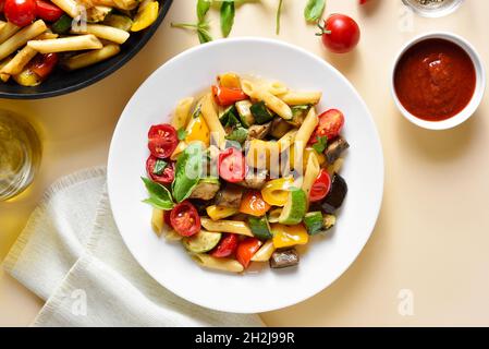 Salade de pâtes Ratatouille sur une assiette sur fond clair.Vue de dessus, plan d'appartement Banque D'Images