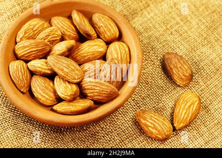 De belles amandes décortiquées dans un bol sur fond de toile de fond Banque D'Images